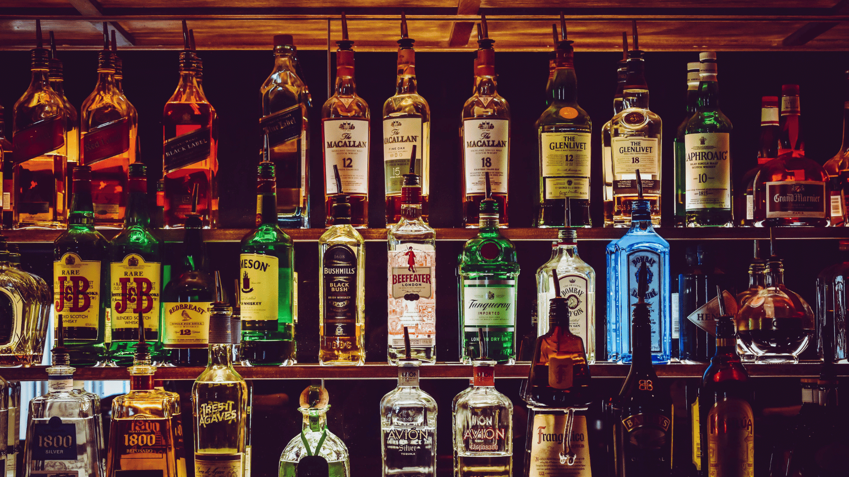 Shelves filled with various bottles of liquor at a bar.