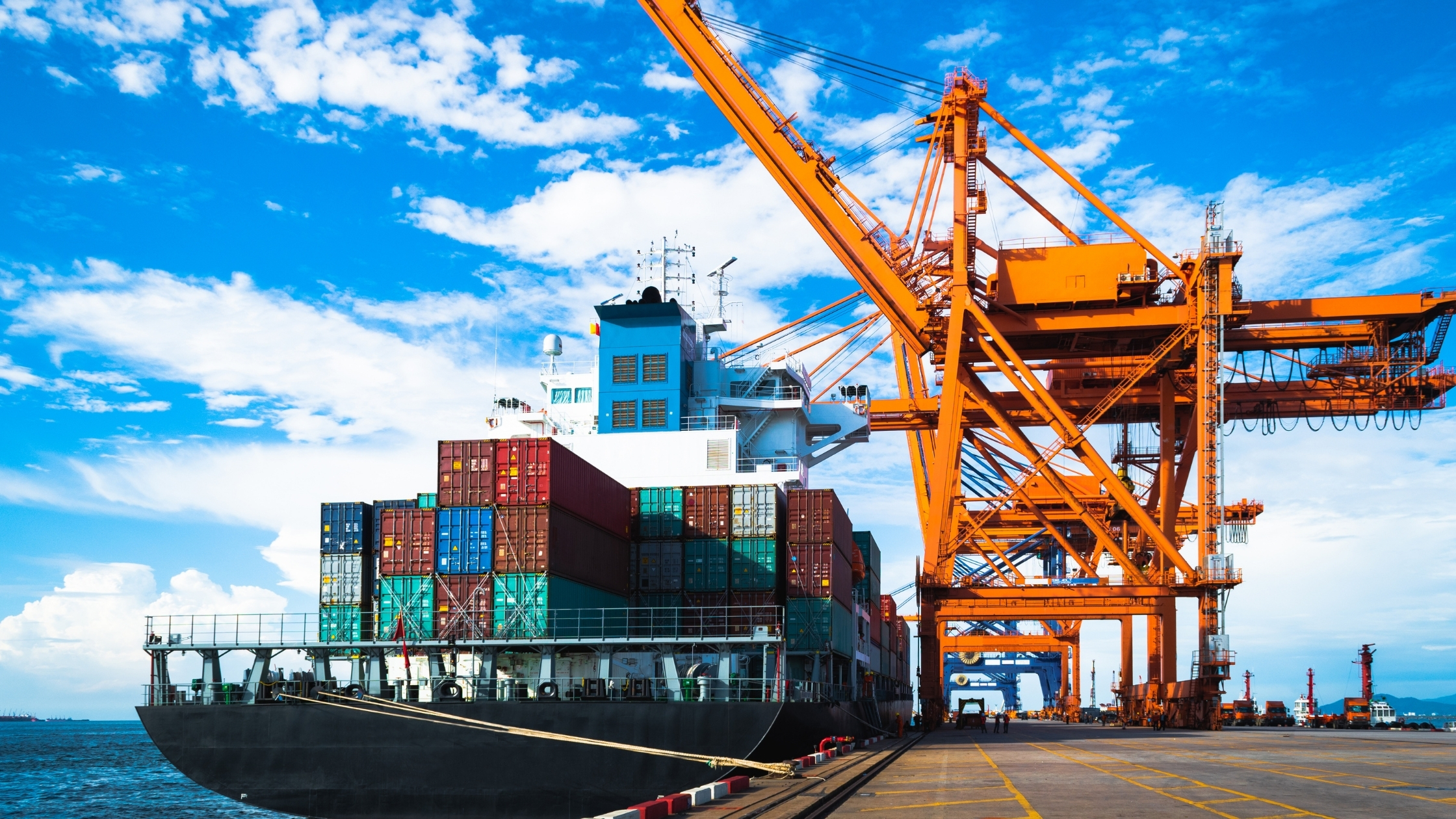Large container ship discharging and loading container cargo at port terminal