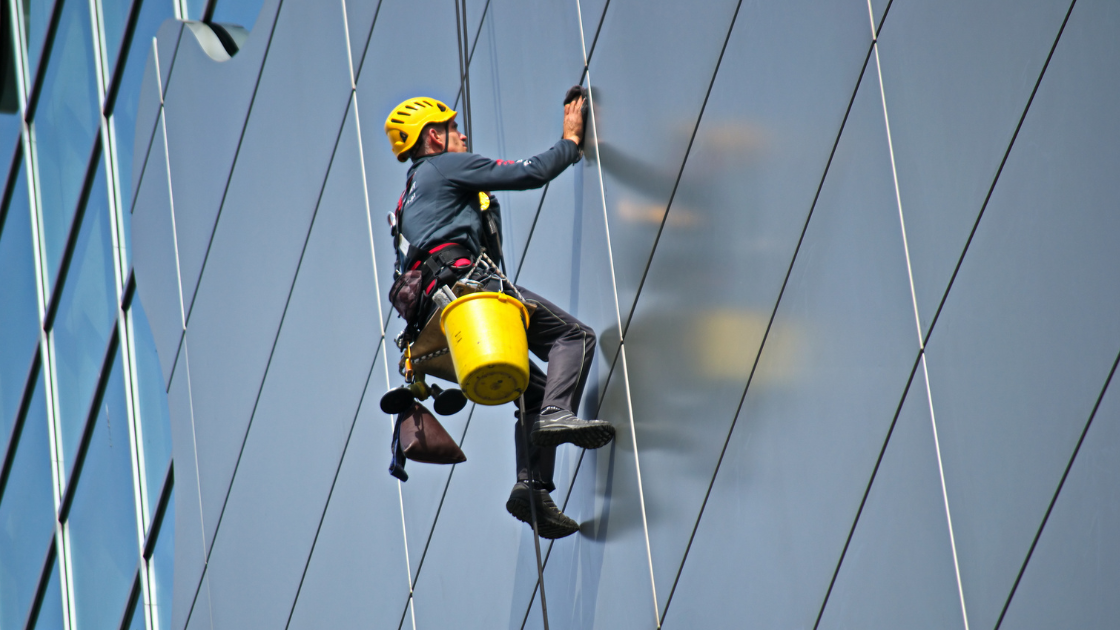 Man Cleaning the Glass of Building