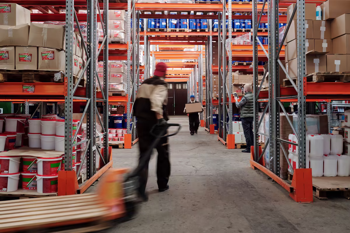 Warehouse workers moving and reviewing inventory between storage racks